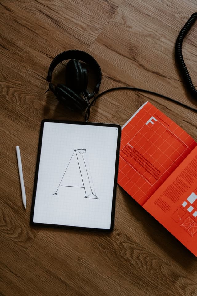 Grafisk Design. Bild på logotyp gjord av lean designs. Bokstaven 'A' på ett ritblock på ett träbord.